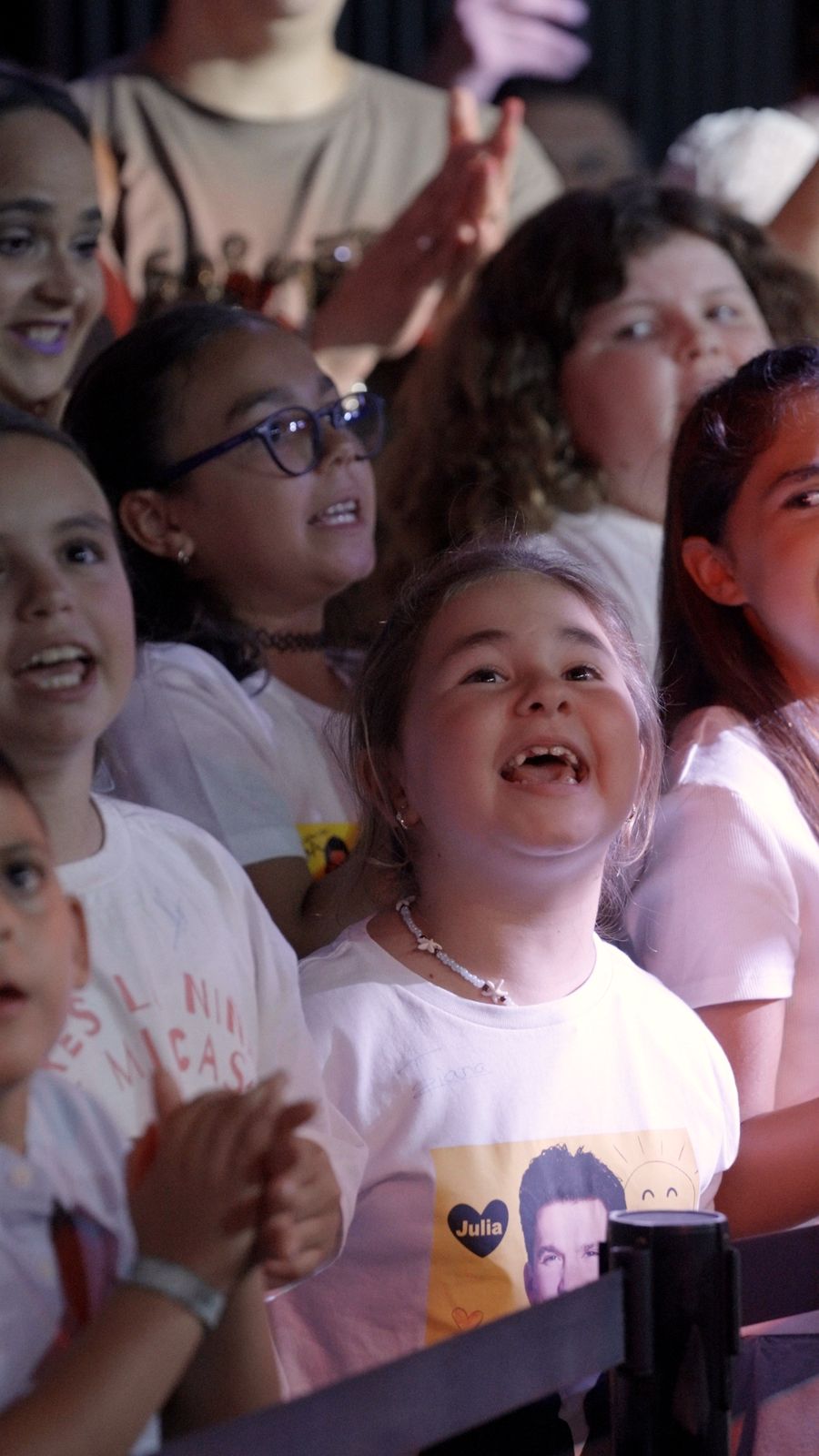 Niñas cantando en primera fila en un concierto de Paulo Domínguez