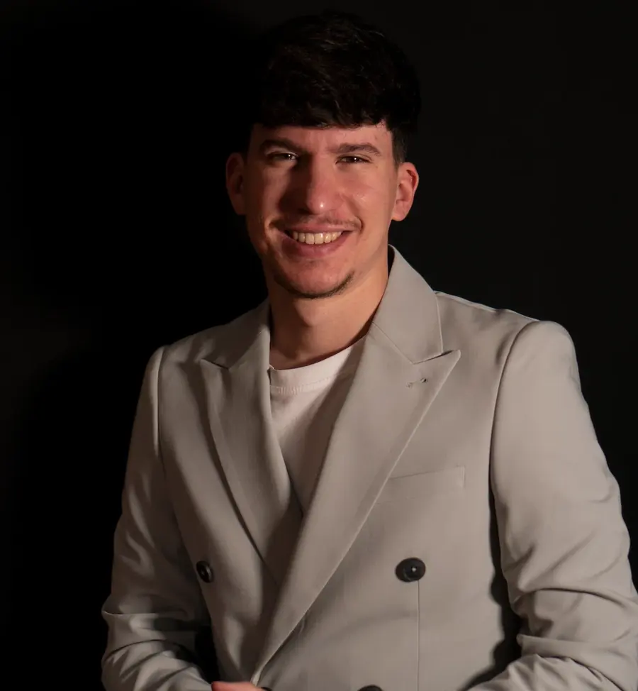 Paulo Domínguez con americana beige sobre fondo negro
